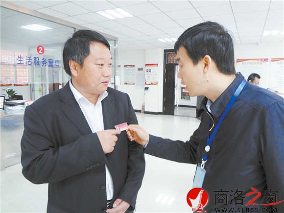 在鎮安縣新城社區便民服務大廳里,參會人員對社區工作人員掛牌上崗很感興趣。(記者 柯巖 攝)